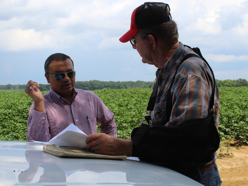 Agronomy researcher and farmer discussing results of research in field